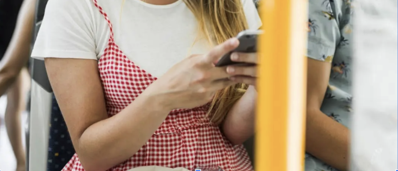 Girl using mobile phone on bus