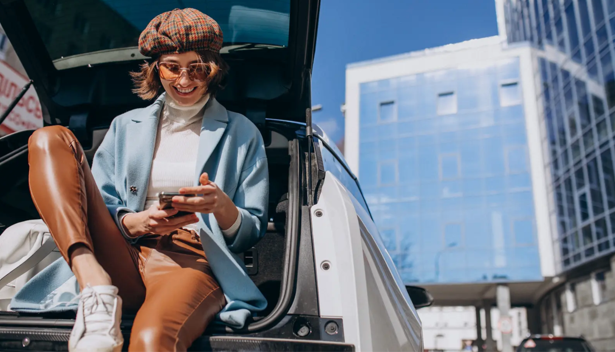 Woman sitting back car looking at phone